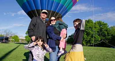 Family in front of hot air balloon at Annual Frolic in the Park